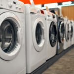Household appliances and gadgets store An assortment of beautiful stylish washing machines on showcases in a gadget, electronics and household appliances store.