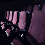 red seats in empty dark movie theater red seats in empty dark movie theater